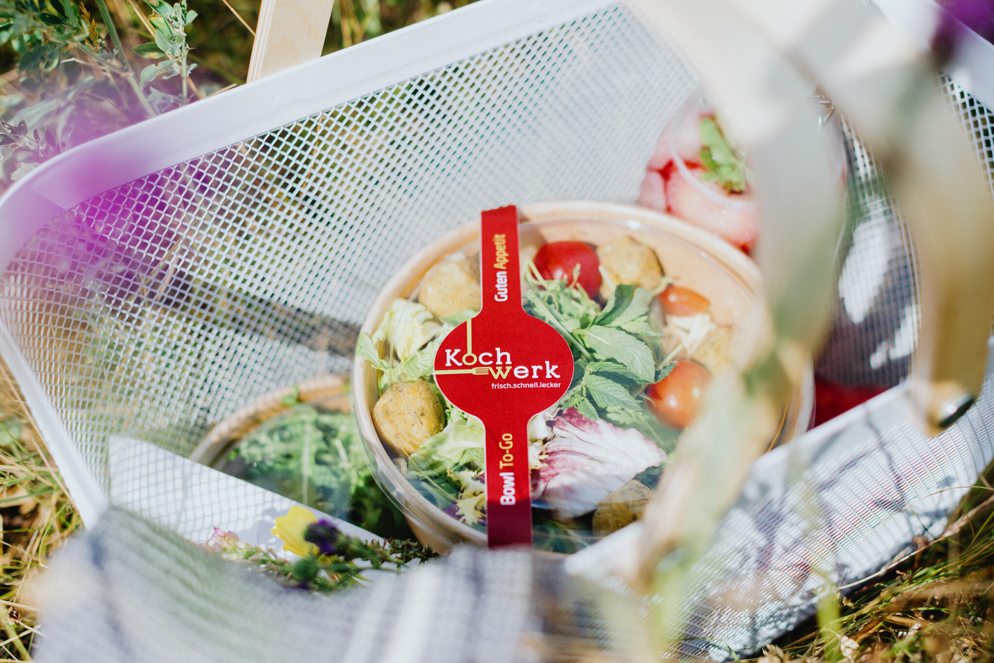 Eine Salatbowl in einem Korb auf einer Wiese